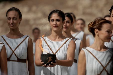 Olympics - Dress Rehearsal - Lighting Ceremony of the Olympic Flame Pyeongchang 2018 - Ancient Olympia, Olympia, Greece - October 23, 2017 Actresses with the flame during the dress rehearsal for the Olympic flame lighting ceremony for the Pyeongchang 2018 Winter Olympic Games at the site of ancient Olympia in Greece REUTERS/Alkis Konstantinidis