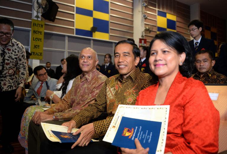 Indonesian President Joko Widodo (C) and First Lady Iriana attend the high school graduation ceremony of their youngest son Kaesang Pangarep, at the Anglo-Chinese International School in Singapore, on November 21, 2014