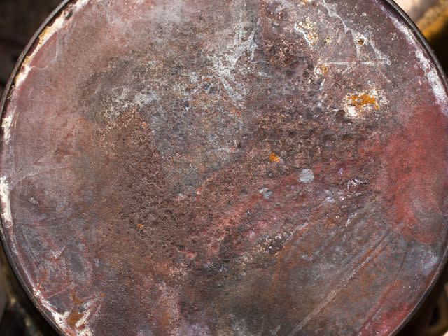Some considerable pitting and erosion on a skillet's underside.