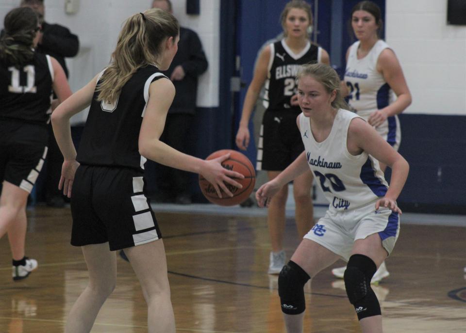 Mackinaw City junior guard Gracie Beauchamp (20) defends Ellsworth guard Avery Strange (5) during the first half of a varsity girls basketball matchup in Mackinaw City on Tuesday.