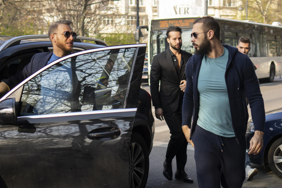 Andrew Tate, right, and his brother Tristan arrive outside the Directorate for Investigating Organized Crime and Terrorism (DIICOT), where prosecutors examine electronic equipment confiscated during the investigation in their case, in Bucharest, Romania, Monday, April 10, 2023. (AP Photo/Vadim Ghirda)