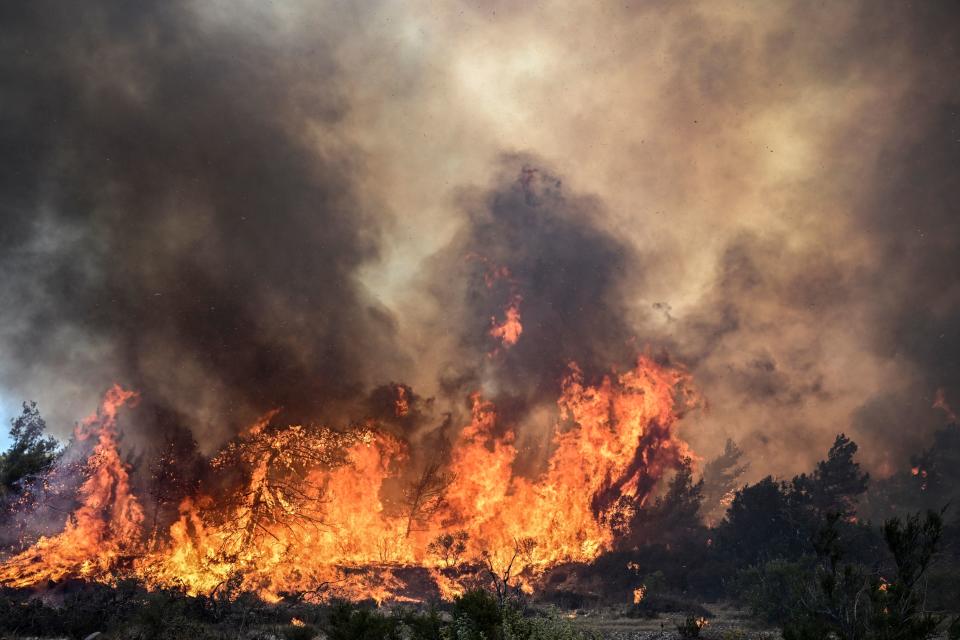 Wildfires burn the forests near the village of Vati, just north of the coastal town of Gennadi, in the southern part of the Greek island of Rhodes, on July 25, 2023. Some 30,000 people fled the flames on Rhodes during the weekend, the country's largest-ever wildfire evacuation as the Greek Prime Minister warned that the heat-battered nation was 