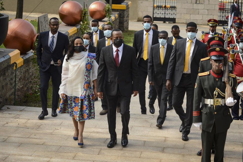 Ethiopia's Prime Minister Abiy Ahmed, center, walks with First Lady Zinash Tayachew, left, as he arrives to be sworn in for a second five-year term, at the House of Peoples Representatives in the capital Addis Ababa, Ethiopia Monday, Oct. 4, 2021. The prime minister, the 2019 Nobel Peace Prize winner for restoring ties with neighboring Eritrea and for pursuing sweeping political reforms, now faces major challenges as war in the Tigray region spreads into other parts of the country. (AP Photo)