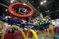 Attendees try out a roller coaster where the cars spin and turn on display at the International Association of Amusement Parks and Attractions convention Tuesday, Nov. 19, 2019, in Orlando, Fla. (AP Photo/John Raoux)
