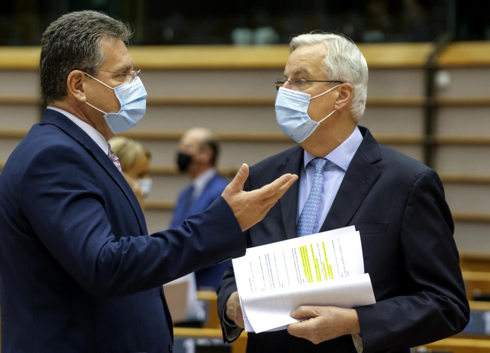 European Commission's Head of Task Force for Relations with the United Kingdom Michel Barnier, right, speaks with European Commissioner for Inter-institutional Relations and Foresight Maros Sefcovic ahead of a report of last weeks EU summit during a plenary session at the European Parliament in Brussels, Wednesday, Oct. 21, 2020. (Olivier Hoslet, Pool via AP)