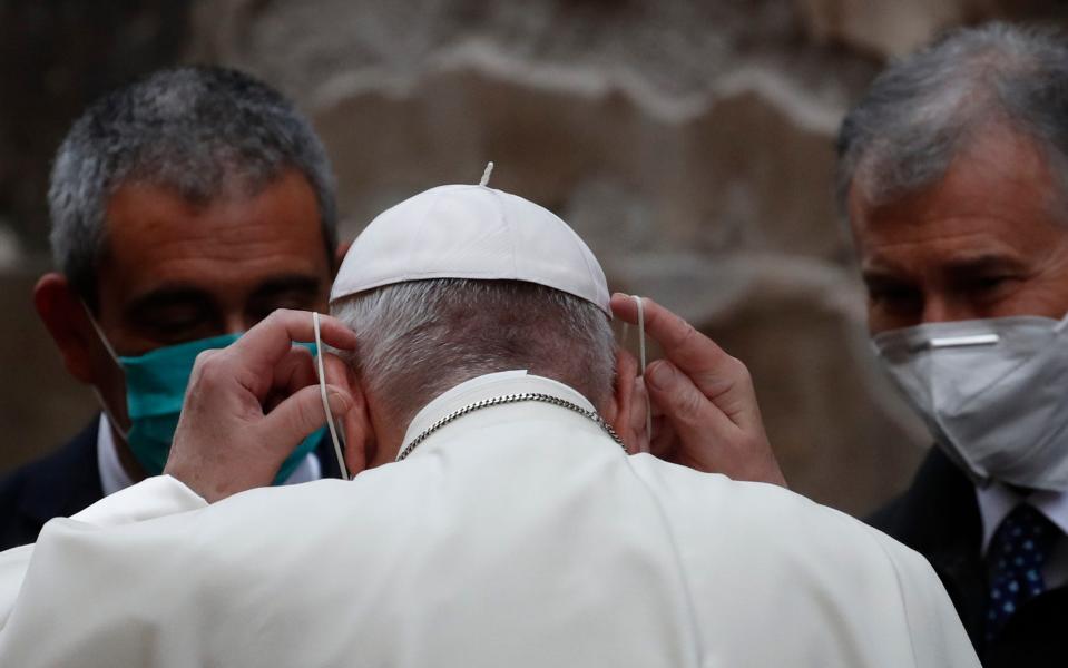 Pope Francis puts on a face mask to curb the spread of COVID-19, as he leaves after a mass in the Santo Spirito in Sassia Church in Rome - Alessandra Tarantino / AP