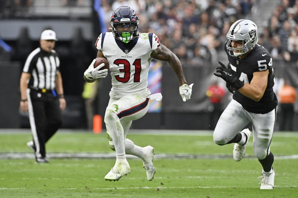 Houston Texans running back Dameon Pierce (31) runs with the ball as Las Vegas Raiders linebacker Blake Martinez defends during the first half of an NFL football game Sunday, Oct. 23, 2022, in Las Vegas. (AP Photo/David Becker)