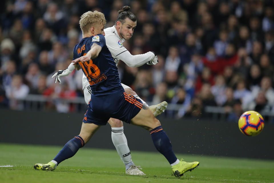 Real Madrid's Gareth Bale, right, shoots past Valencia's Daniel Wass during a Spanish La Liga soccer match between Real Madrid and Valencia at the Santiago Bernabeu stadium in Madrid, Spain, Saturday, Dec. 1, 2018. (AP Photo/Paul White)