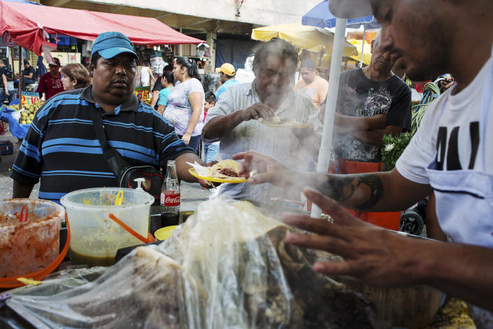 <p>Benito Gutierréz Moreno, 40, gets a snack from a street vendor. He suffers from severe obesity and says he is not aiming to change his diet or lifestyle. (Photograph by Silvia Landi) </p>