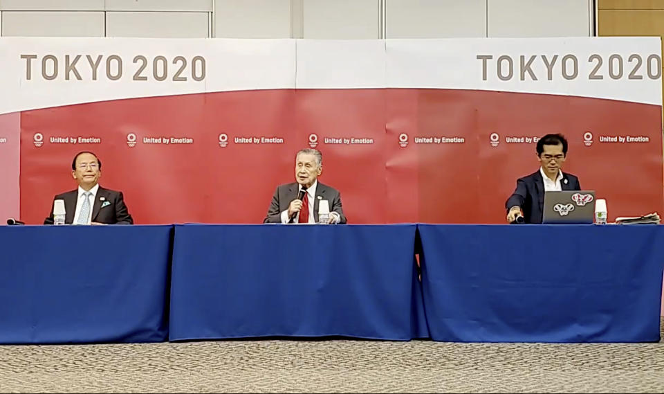 In this image made from video provided by Tokyo 2020 Official YouTube Channel, Tokyo 2020 Olympics President Yoshiro Mori, center, with CEO Toshiro Muto, left, attends a press conference after an IOC executive board meeting in Tokyo, Wednesday, June 10, 2020. (Tokyo 2020 Official YouTube Channel via AP)