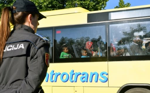 A police officer guards a bus carrying migrants evacuated from a makeshift camp in Sarajevo