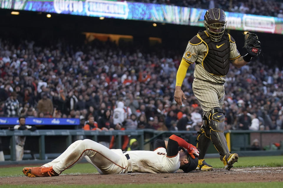 San Francisco Giants' Blake Sabol, bottom, reacts after scoring against San Diego Padres catcher Gary Sanchez during the fifth inning of a baseball game in San Francisco, Wednesday, June 21, 2023. Sabol was initially called out but was ruled safe after the Giants challenged. (AP Photo/Jeff Chiu)