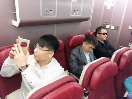 Passengers believed to be North Koreans including Kim Uk Il (L) are seen inside an airplane for the flight bound for Beijing, at an airport in Kuala Lumpur in Malaysia. Kyodo/via REUTERS