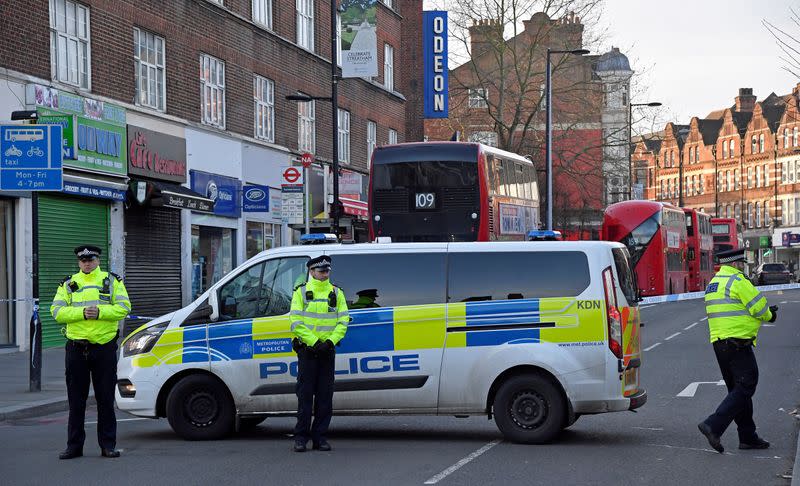 Police officers are seen near the site where a man was shot by armed officers in Streatham, south London