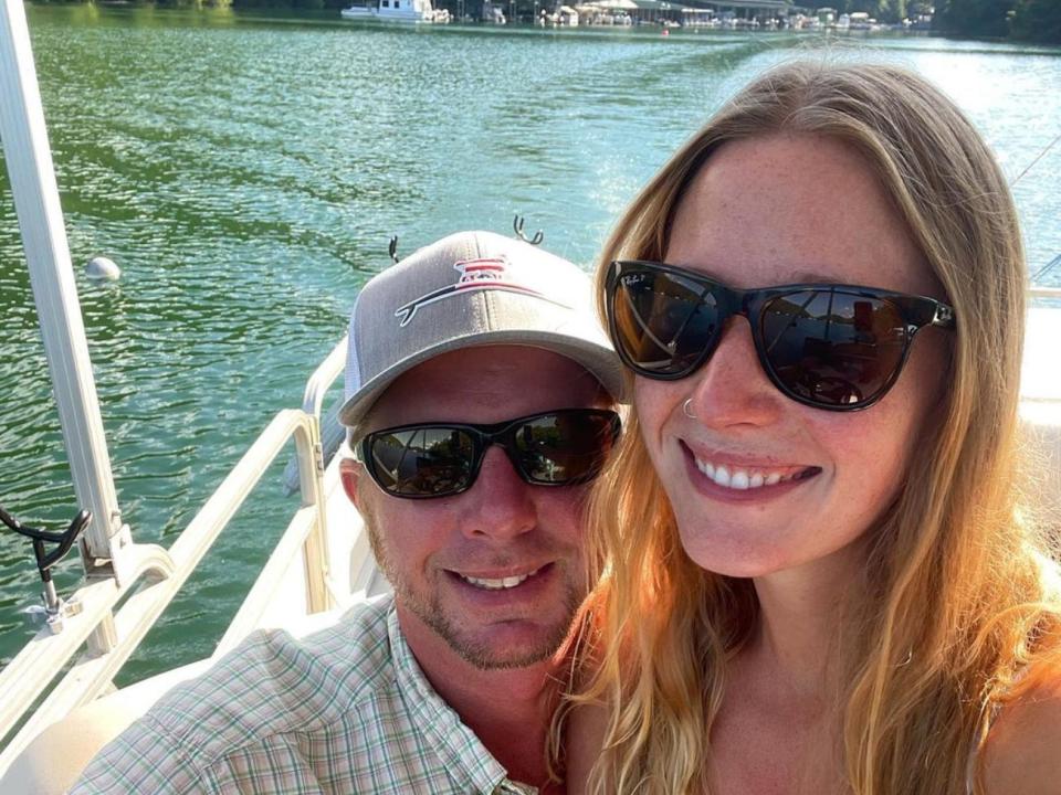 A man and a woman taking a selfie while on a lake.