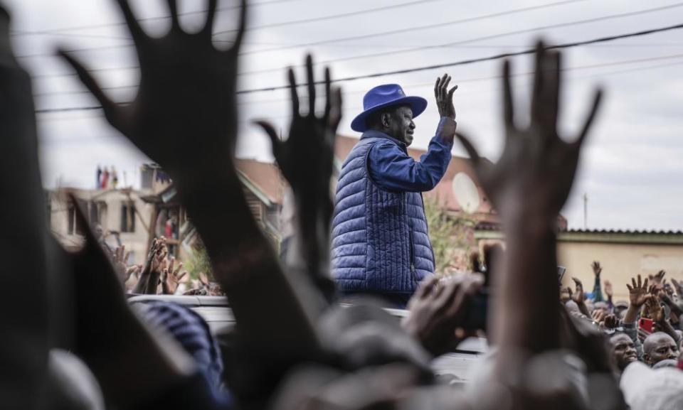 Raila Odinga waves to his supporters after casting his vote at a primary school in Nairobi.