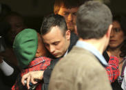 Oscar Pistorius, center, shares a hug with an unidentified woman as he leaves the high court in Pretoria, South Africa, Wednesday, April 16, 2014. Pistorius is charged with murder for the shooting death of his girlfriend, Reeva Steenkamp, on Valentines Day in 2013. (AP Photo/Themba Hadebe)