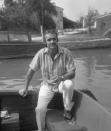 <p>Connery, wearing a striped short sleeves shirt, linen trousers, slippers and sunglasses, sitting on a water taxi with Torcello Island on the background, Venice, circa 1970. </p>