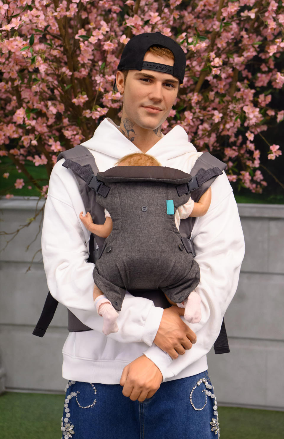 Caption: Baby, Baby, Baby, Oh! In celebration of Justin and Hailey Bieber's baby news Madame Tussauds London has dressed the dad-to-be with a baby carrier to help him get some all-important practice in ahead of the big arrival. Fans of the 'Baby' superstar can see the figure at the Baker Street attraction.