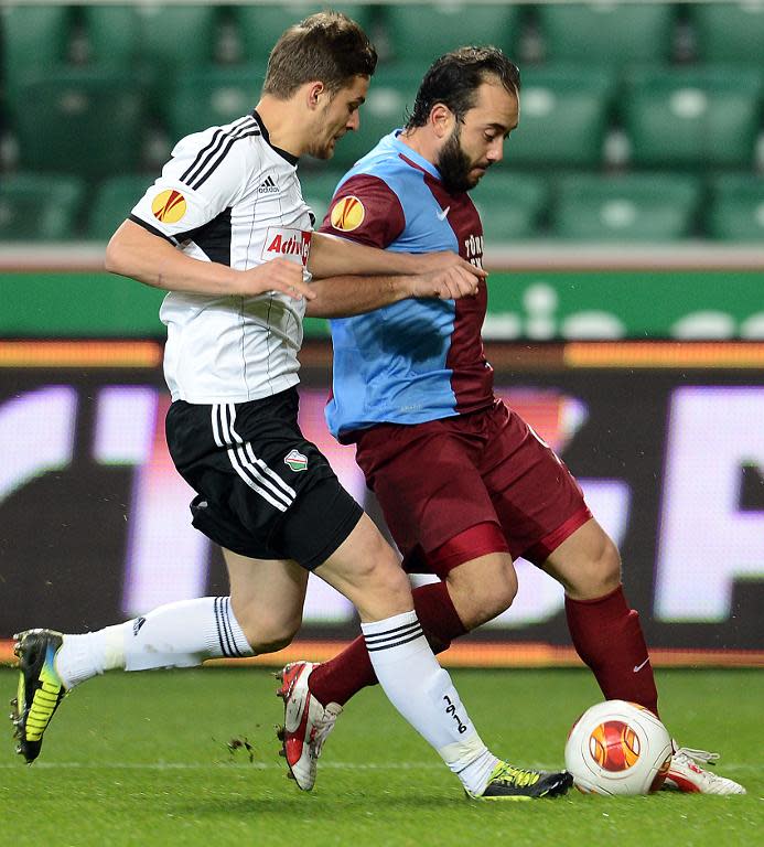 Legia Warsaw defender Bartosz Bereszynski (L) vies for the ball with Trabzonspor midfielder Olcan Adin during a UEFA Europa League match on Novemver 7, 2013 in Warsaw