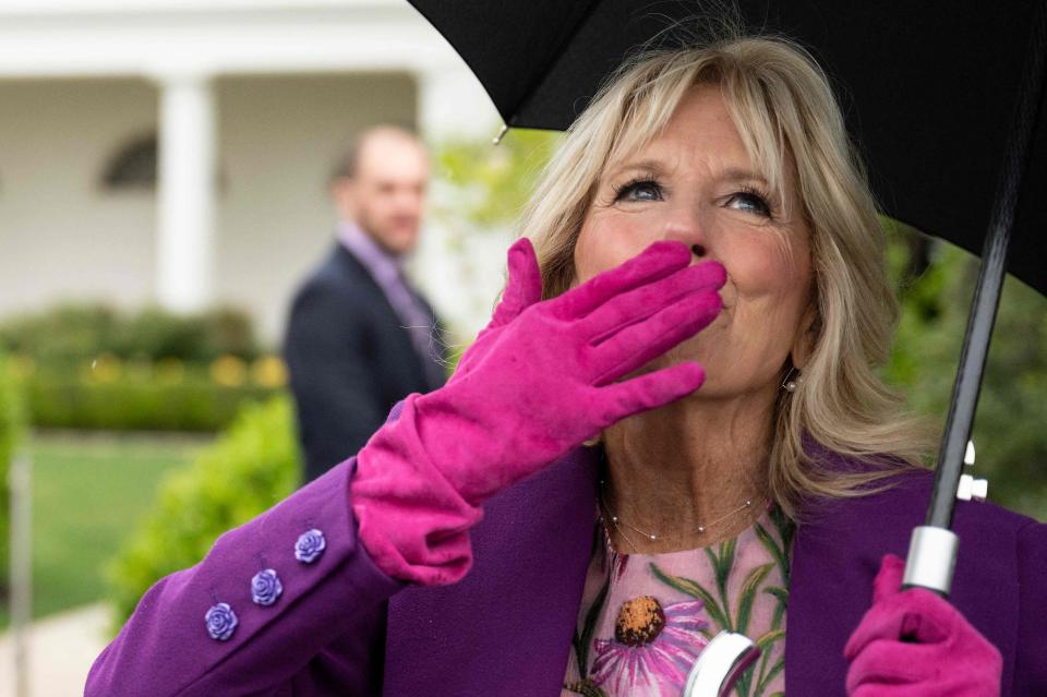 First Lady Jill Biden blows kisses to the crowd during the rainy White House Easter Egg roll on the South Lawn of the White House on April 18, 2022.