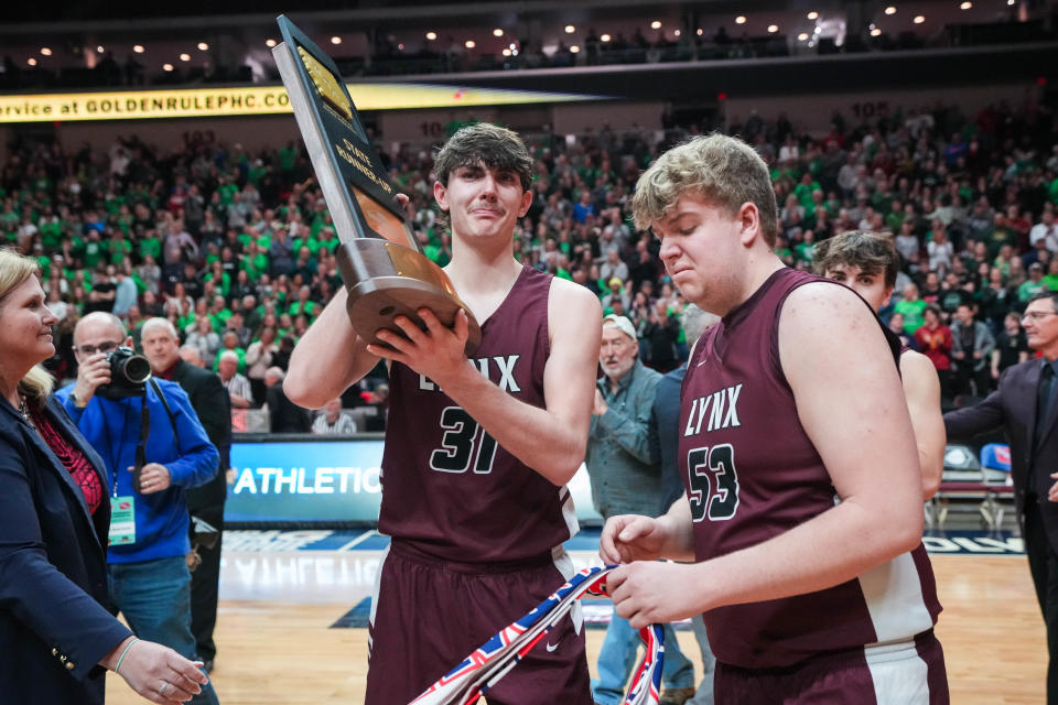 North Linn seniors Tate Haughenbury (31) and Grant Rechkemmer (53) receiver their teams banner and runner-up trophy after losing to Grand View Christian in the class 1A championship game.