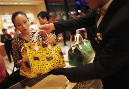 A woman shops in a Louis Vuitton store during Vogue's 4th Fashion's Night Out: Shopping Night with Celebrities in downtown Shanghai in this September 7, 2012 file photograph. REUTERS/Carlos Barria/Files