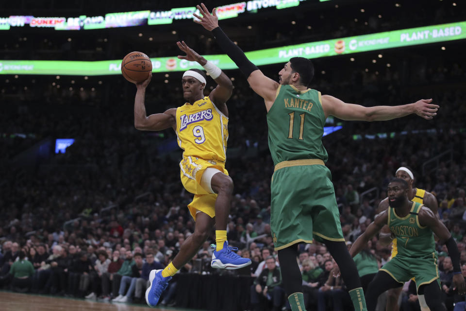 Los Angeles Lakers guard Rajon Rondo (9) passes the ball as he is pressured by Boston Celtics center Enes Kanter (11) during the fourth quarter of an NBA basketball game in Boston, Monday, Jan. 20, 2020. (AP Photo/Charles Krupa)