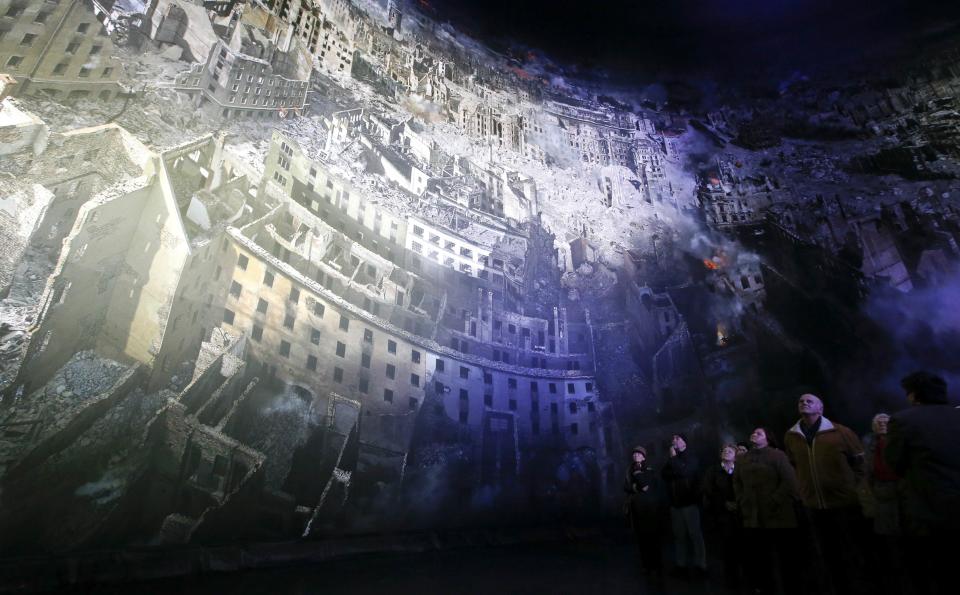 Visitors watch the 'Dresden 1945' 360 degrees panorama showing the destroyed city of Dresden after the bombing raids during the World War Two in February 1945 at the Panometer in Dresden