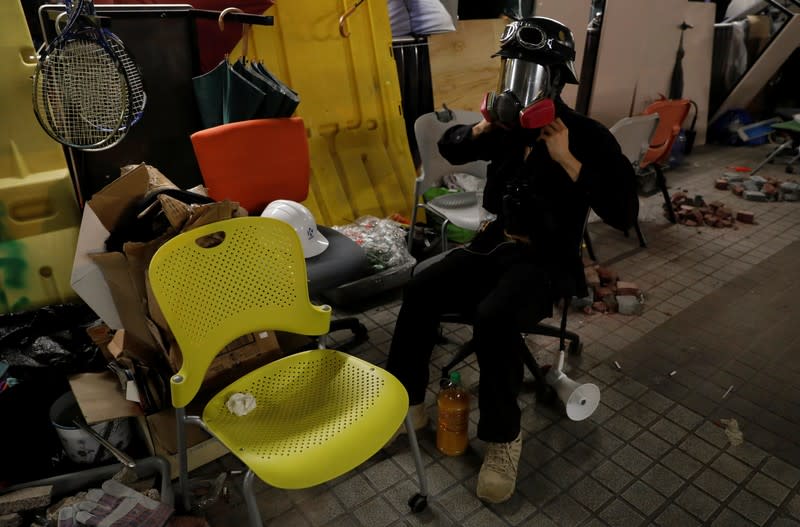 An anti-government protester adjusts his gas mask outside the Polytechnic University in Hong Kong