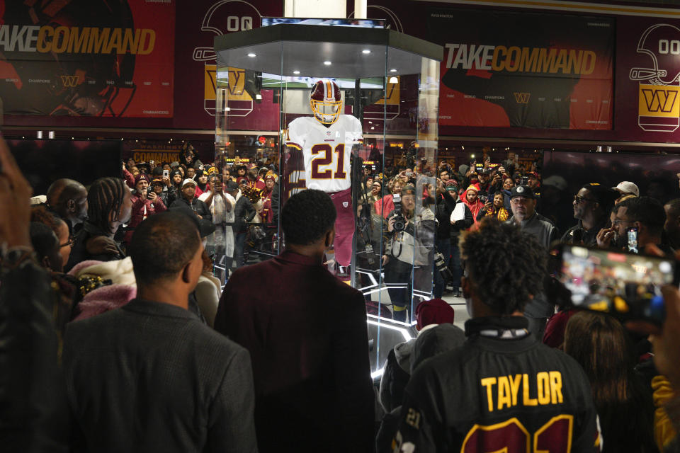 Fans attends the unveiling of the Sean Taylor Memorial, before the start of an NFL football game between the Atlanta Falcons and Washington Commanders, Sunday, Nov. 27, 2022, in Landover, Md. On the 15th anniversary of the death of Taylor, ever Commander player will wear a No. 21 decal on their helmet. (AP Photo/Jessica Rapfogel)