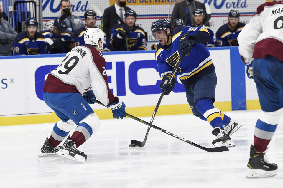 Colorado Avalanche's Nathan MacKinnon (29) defends against St. Louis Blues' David Perron (57) during the second period of an NHL hockey game on Wednesday, April 14, 2021, in St. Louis. (AP Photo/Joe Puetz)