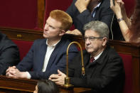 FILE - French far-left leader Jean-Luc Melenchon, right, and deputy Adrien Quatennens, listen to Ukrainian President Volodymyr Zelenskyy addressing the French National Assembly, Wednesday, March 23, 2022 in Paris. Prominent French legislator Adrien Quatennens, of the far-left France Unbowed party, recently acknowledged slapping his wife, and influential three-time presidential candidate Jean-Luc Melenchon initially defended him. Quatennens stepped down from his role as party coordinator, and Melenchon came under criticism within their leftist camp. It is the latest of several cases involving French political figures accused of harming or harassing women that have prompted calls for change. (AP Photo/Francois Mori, File)