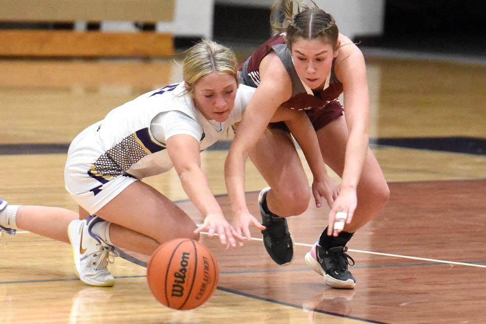 Fowlerville's Angelle Haan (left) and Milford's Madison Stevens dive for a loose ball during a season-opening basketball game Monday, Dec. 4, 2023.
