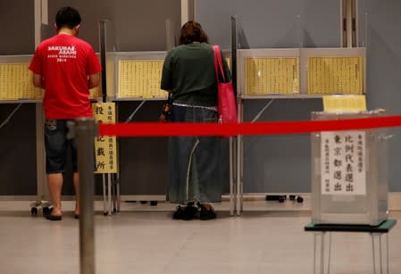 Voters fill out their ballots for Japan's upper house election at a polling station in Tokyo
