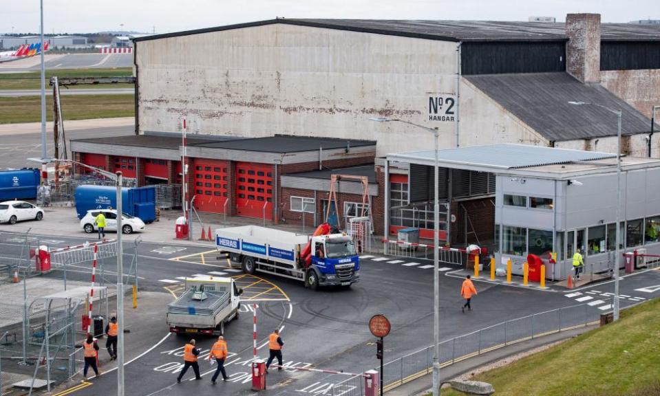 Workers outside a hangar at Birmingham airport, which is being converted into a large morgue.