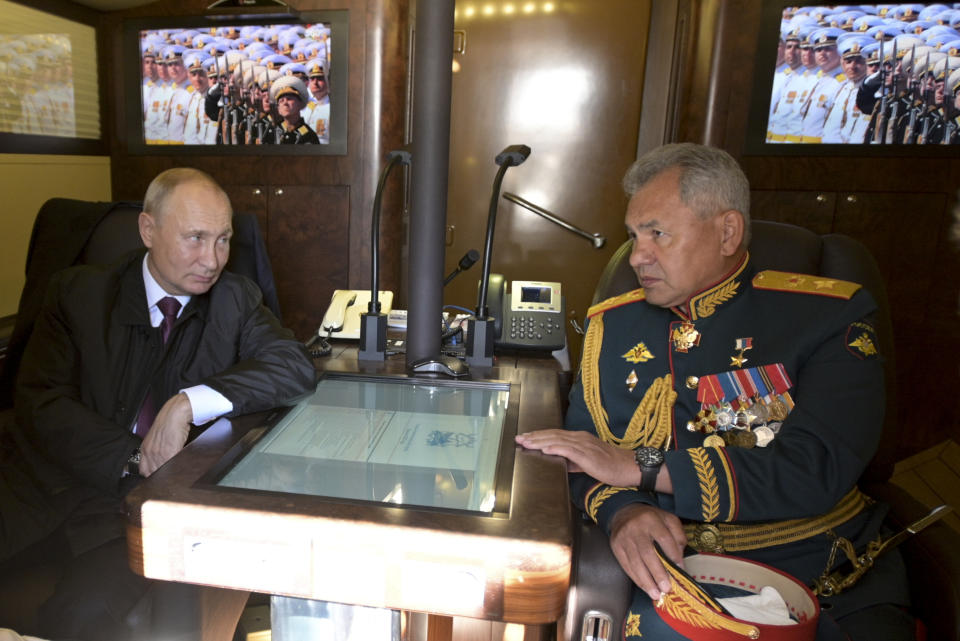 Russian President Vladimir Putin, left, and Defense Minister Sergei Shoigu talk while aboard a ship on their way to attend the military parade during the Navy Day celebration in Kronshtadt outside St.Petersburg, Russia, Sunday, July 26, 2020. (Alexei Druzhinin, Sputnik, Kremlin Pool Photo via AP)