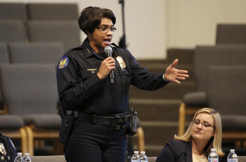 Phoenix Police Chief Jeri Williams speaks at a community meeting, as Phoenix Mayor Kate Gallego, seated, listens, Tuesday, June 18, 2019, in Phoenix. The community meeting stems from reaction to a videotaped encounter that surfaced recently of Dravon Ames and his pregnant fiancee, Iesha Harper, having had guns aimed at them by Phoenix police during a response to a shoplifting report, as well as the issue of recent police-involved shootings in the community. (AP Photo/Ross D. Franklin)