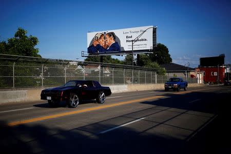 A billboard erected in advance of the Republican National Convention depicts U.S. Republican presidential candidate Donald Trump kissing former presidential candidate Sen. Ted Cruz (R-TX) in Cleveland, Ohio July 15, 2016. REUTERS/Aaron P. Bernstein