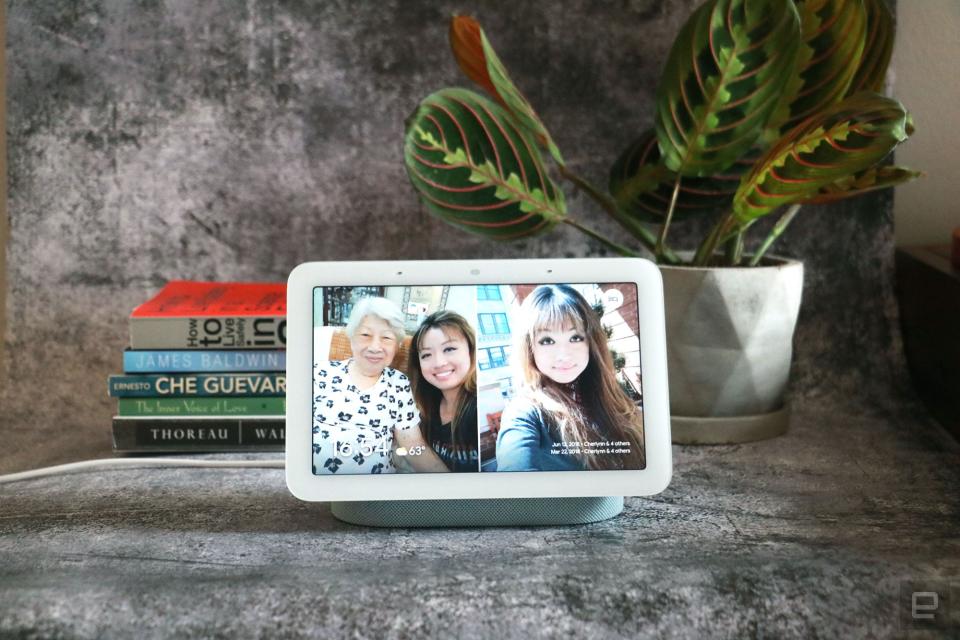 Google Nest Hub 2021 (2nd gen) photo. Picture of Google's newest smart display on a table with books and a plant in the background.