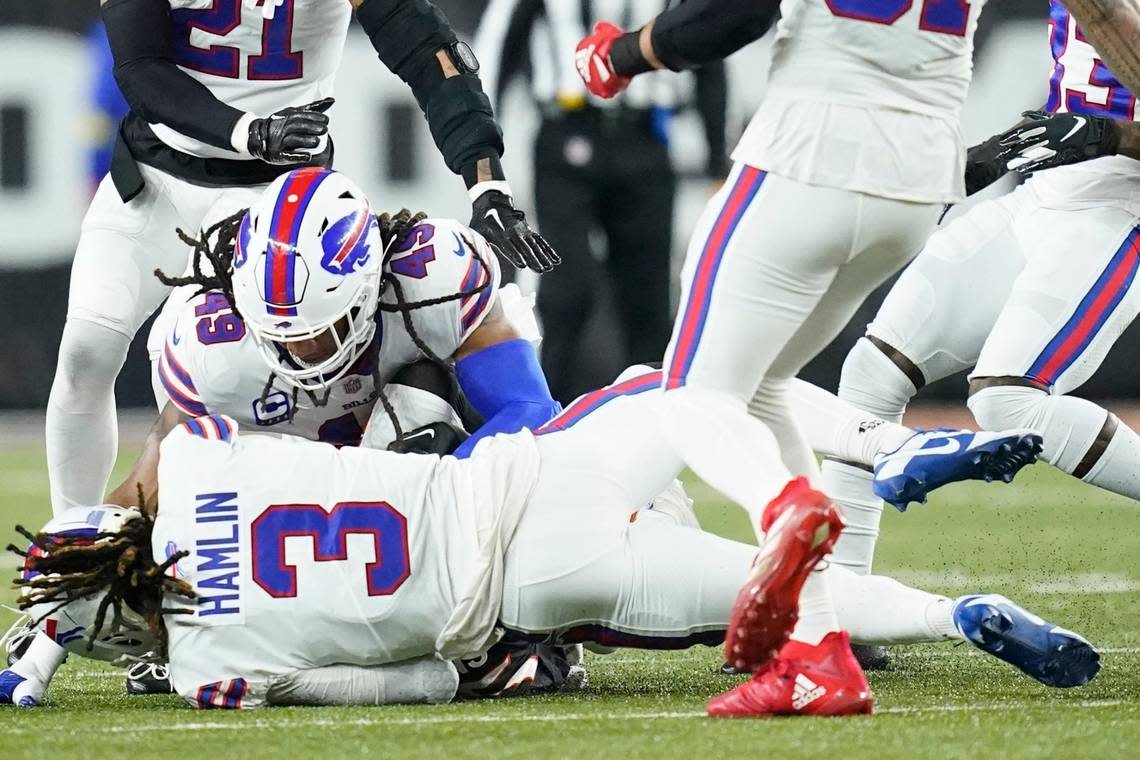 Buffalo Bills safety Damar Hamlin lies on the ground as teammate linebacker Tremaine Edmunds tries to help him recover in a game against the Bengals on January 2, 2023 in Cincinnati.