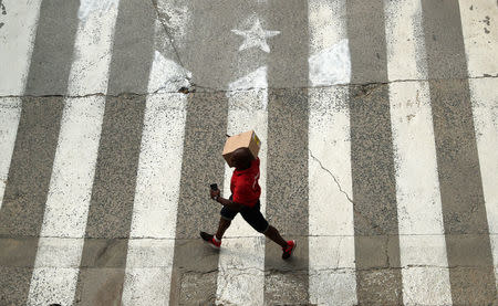 A man walks past a crosswalk, painted in the form of an Estelada (Catalan pro-independence flag) in Arenys de Munt, north of Barcelona, Spain, September 26, 2017. REUTERS/Albert Gea