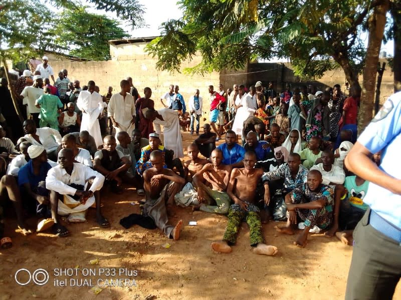 People sit on the ground after being freed by police from an Islamic rehabilitation centre in Ibadan