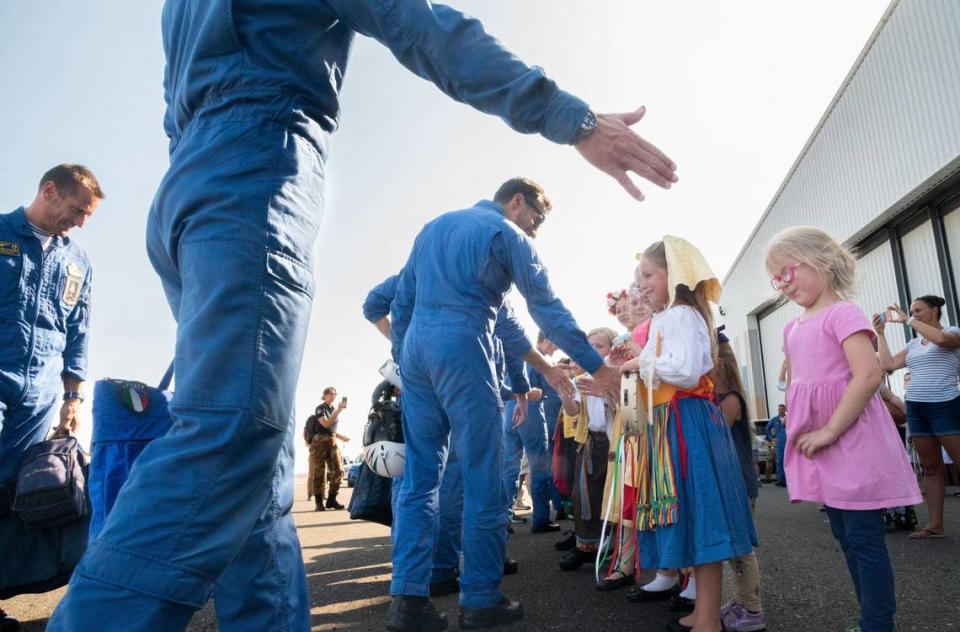 Pilots with Frecce Tricolori, the Italian Air Force aerobatic team, high-five a line of onlookers – some dressed in traditional Italian clothing – after arriving at Mather Airport near Rancho Cordova on Tuesday. This tour is the first time in more than 30 years that the Italian Air Force has deployed its aircraft and personnel to North America.
