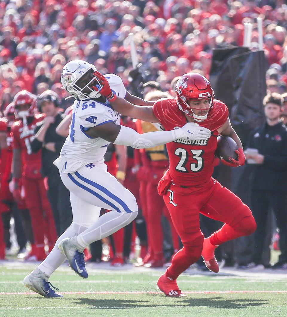 Kentucky Wildcats linebacker D'Eryk Jackson (54) tries to stop Louisville Cardinals running back Isaac Guerendo (23) in the first half of the 2023 Governor's Cup game in Louisville. Nov. 24, 2023