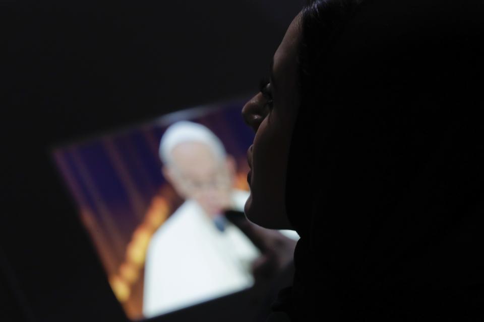 A woman looks at a monitor broadcasting the image of Pope Francis speaking during an Interreligious meeting at the Founder's Memorial in Abu Dhabi, United Arab Emirates, Monday, Feb. 4, 2019. Pope Francis arrived in Abu Dhabi on Sunday. His visit represents the first papal trip ever to the Arabian Peninsula, the birthplace of Islam. (AP Photo/Andrew Medichini)