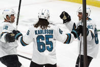 San Jose Sharks' Matt Nieto, right, celebrates his goal off Minnesota Wild goalie Cam Talbot with Patrick Marleau, left, and Erik Karlsson (65) in the first period of an NHL hockey game, Friday, Jan. 22, 2021, in St. Paul, Minn. (AP Photo/Jim Mone)