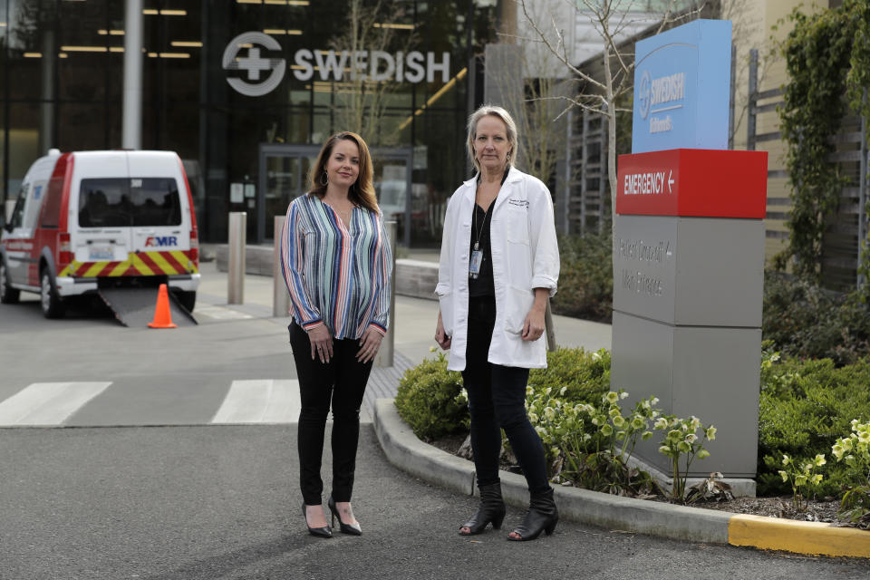 In this Tuesday, March 24, 2020, photo, Melissa Short, left, system executive director for women's health at Swedish Medical Center, and Dr. Tanya Sorensen, a practicing maternal fetal medicine physician at Swedish, and executive director for women's services, pose in front of the center in Edmonds, Wash., north of Seattle. Several dozen expectant moms who had planned to give birth at the birth unit of the center will now have to go elsewhere because the facility is being repurposed to treat victims of the new coronavirus. (AP Photo/Ted S. Warren)