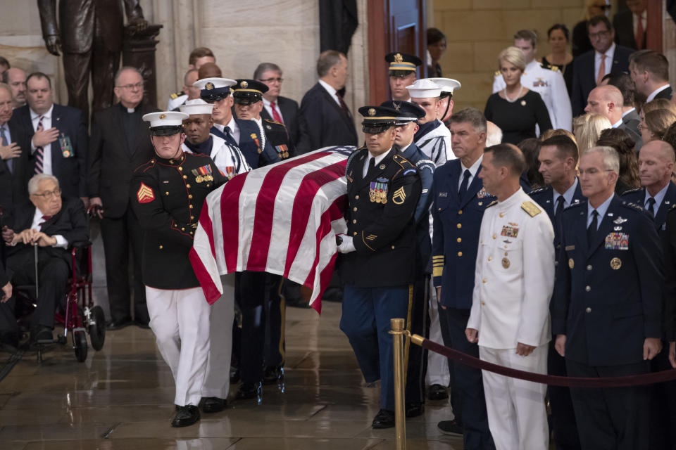 The flag-draped casket bearing the remains of Sen. John McCain of Arizona, who lived and worked in Congress over four decades, is carried into the U.S. Capitol rotunda, followed by his widow, Cindy McCain, upper right, for a farewell ceremony and public visitation, Friday, Aug. 31, 2018, in Washington. (AP Photo/J. Scott Applewhite)