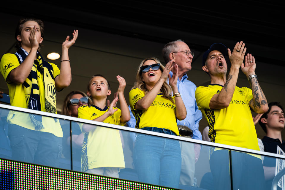 NASHVILLE, TENNESSEE - MAY 01: Reese Witherspoon (2nd from right,) with her sons Deacon Phillippe, Tennessee Toth and her husband Jim Toth, cheers on the Nashville Soccer Club during the Inaugural home opener game between Philadelphia Union and Nashville SC at GEODIS Park on May 01, 2022 in Nashville, Tennessee. (Photo by Keith Griner/Getty Images)